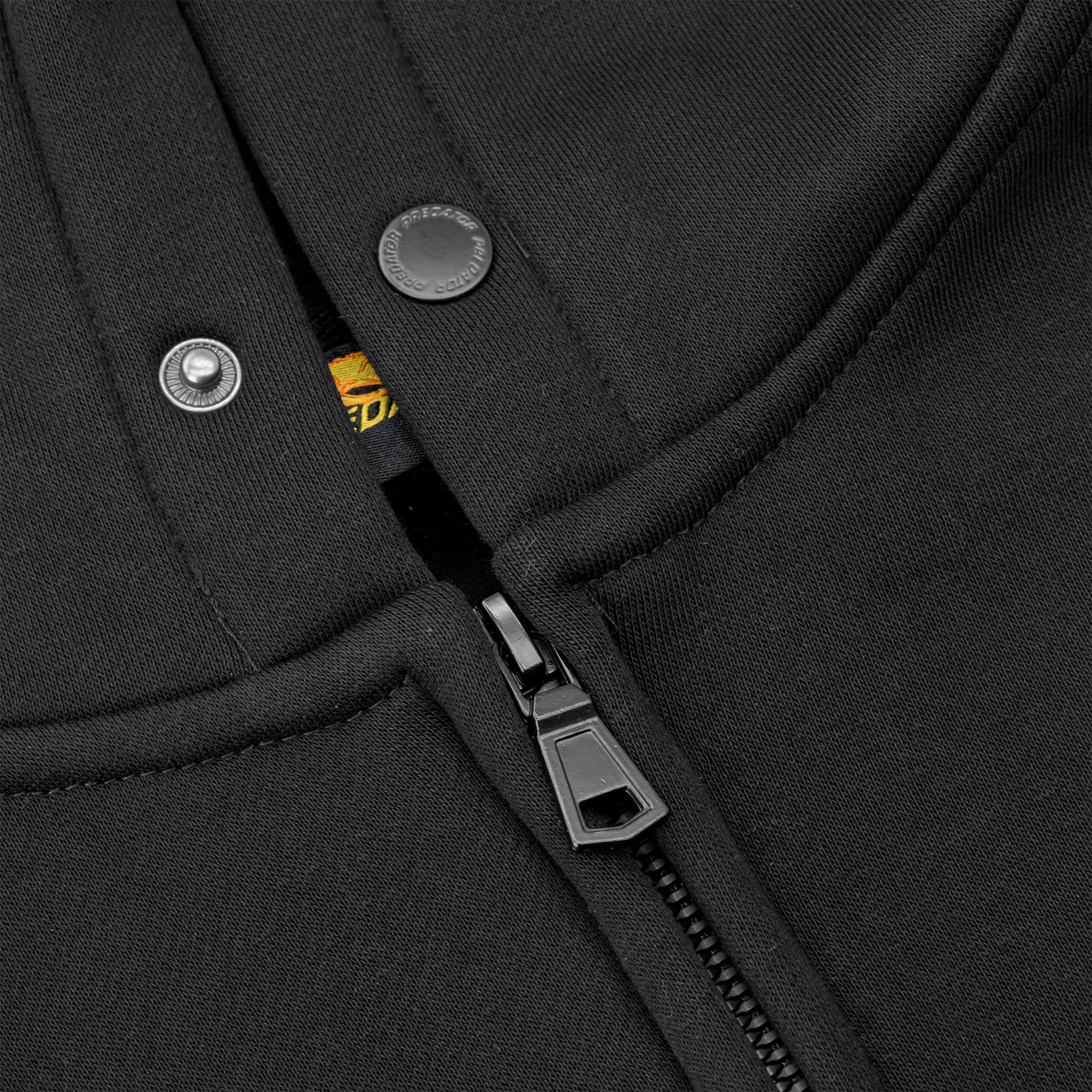 Close-up of a black sweatshirt with zipper and buttons.