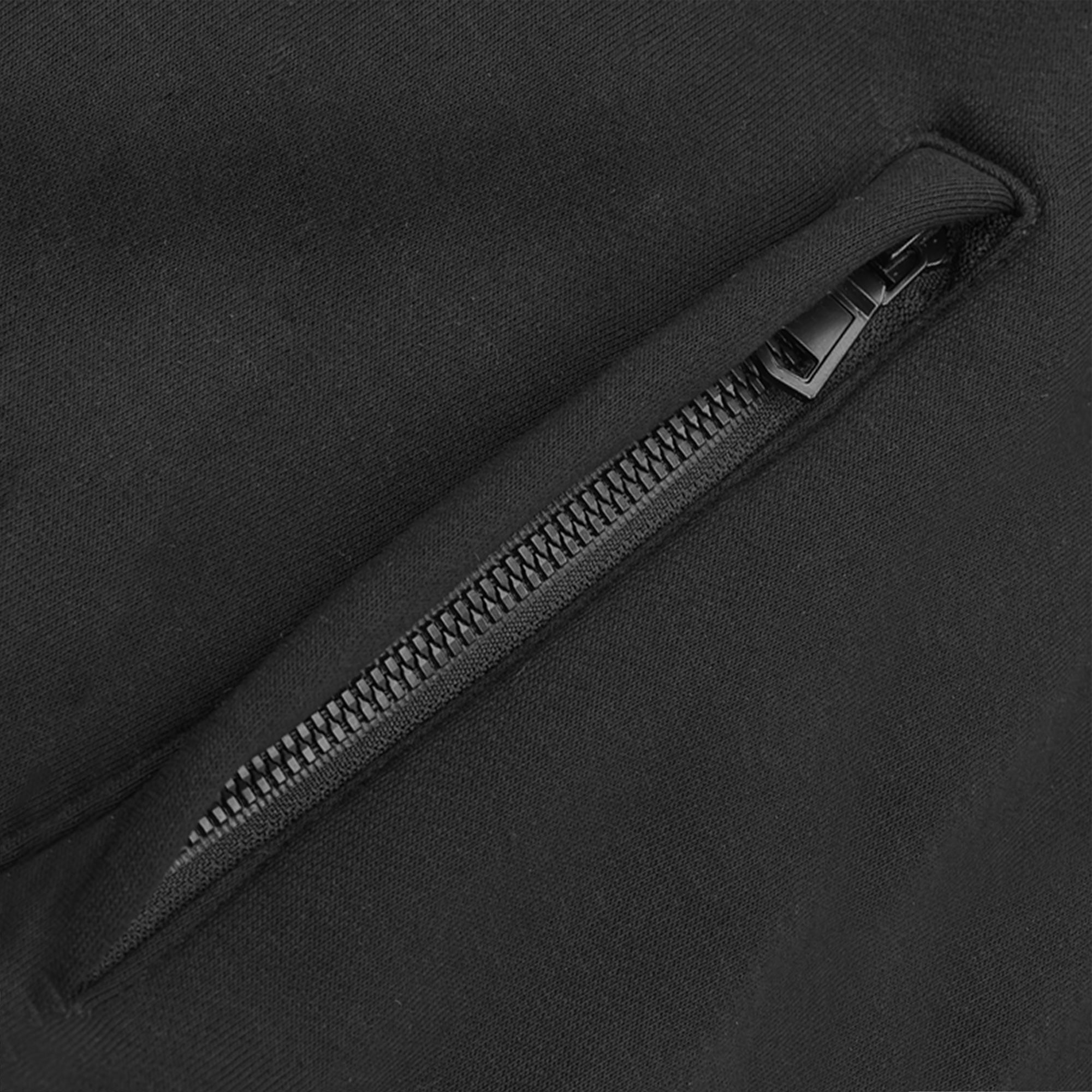 Close-up of a black zipper on a black background.