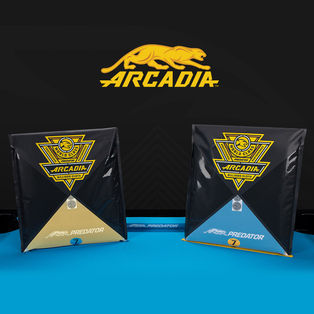 Two black and gold packages with 'Arcadia' branding on a blue surface.