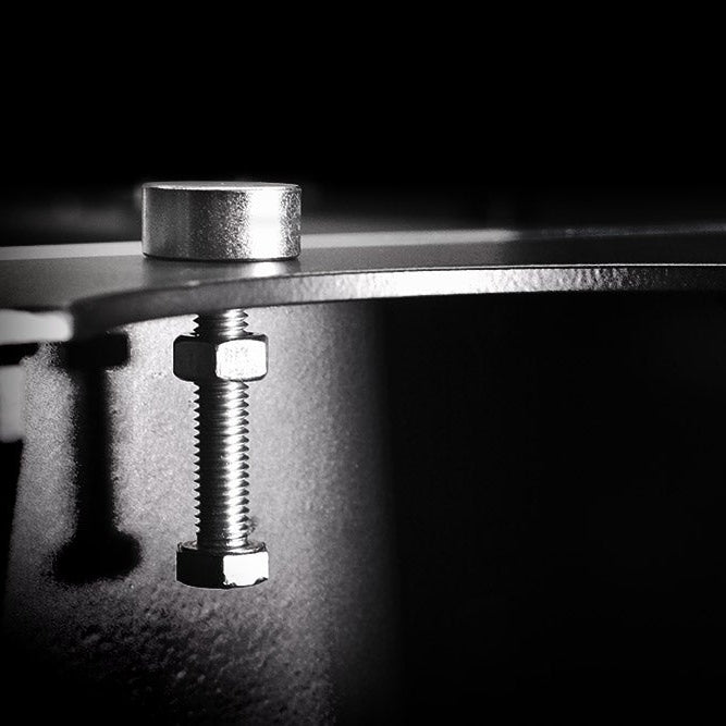 Close-up of a metal bracket with a bolt on a dark background.