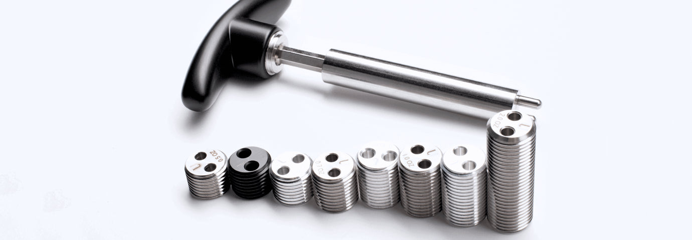 Metal tool with black handle and stack of metal weights
