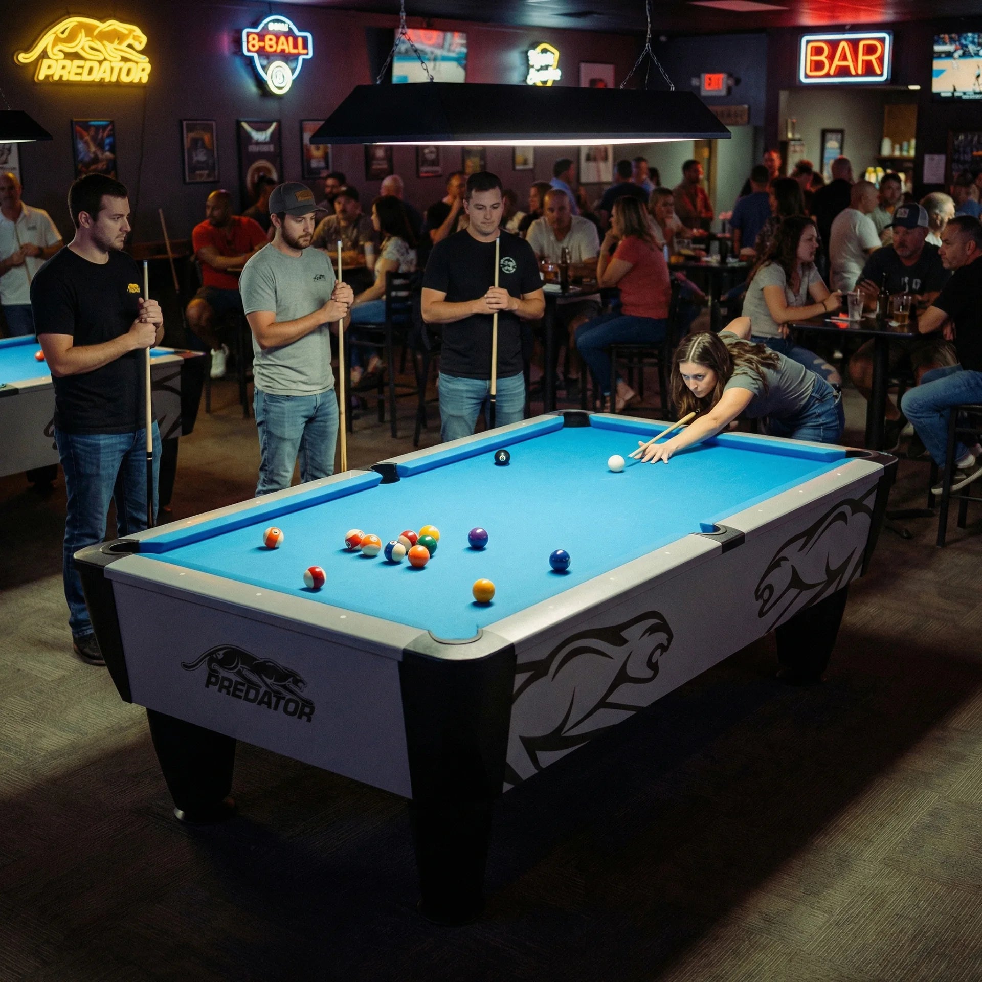 Group of people playing pool in a bar on a Predator Apex table