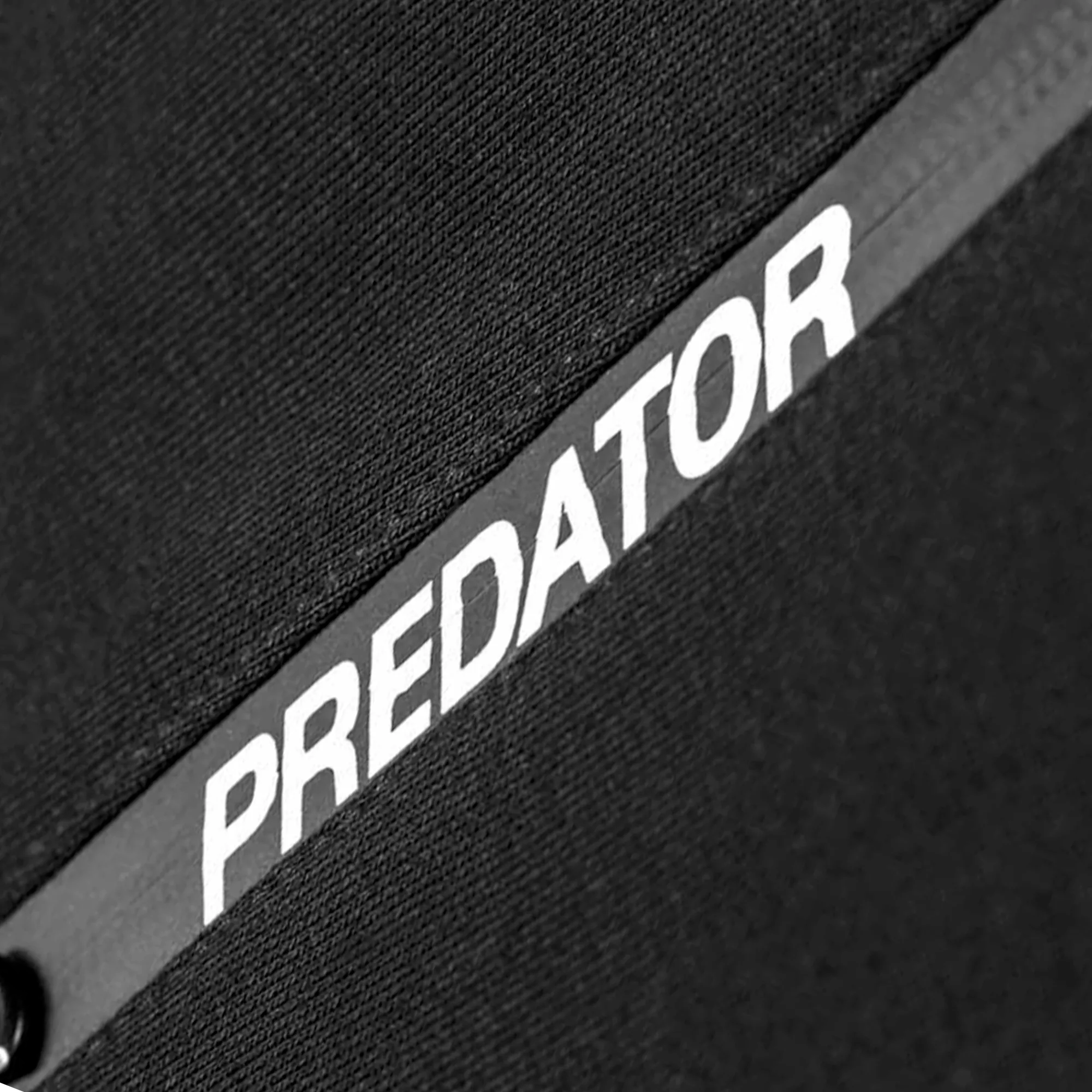 Close-up of a black zipper with 'Predator' branding.