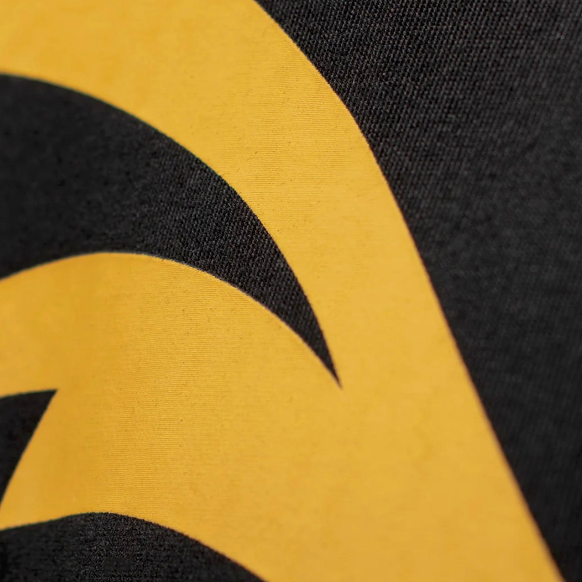 Yellow logo detail against a black fabric background.
