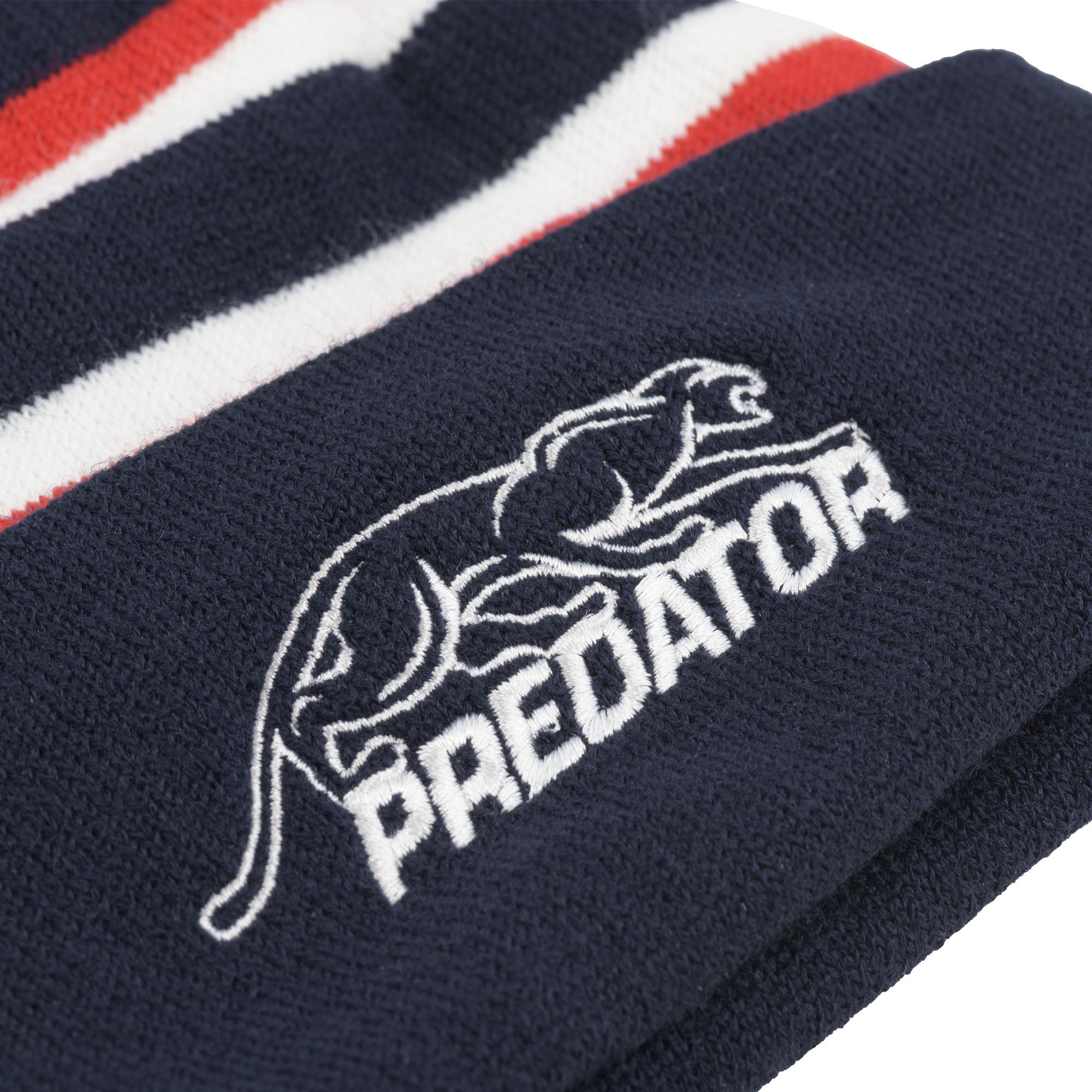 White embroidered Predator logo against a navy blue fabric background.