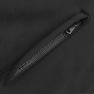 Close-up of a black zipper on a black background.