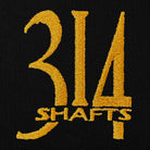 Gold embroidered 314 Shafts logo against a black fabric background. 