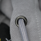 Close-up of a gray textured fabric with a metal grommet.