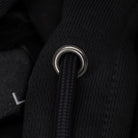Close-up of a black drawstring with a metal ring on a dark background.