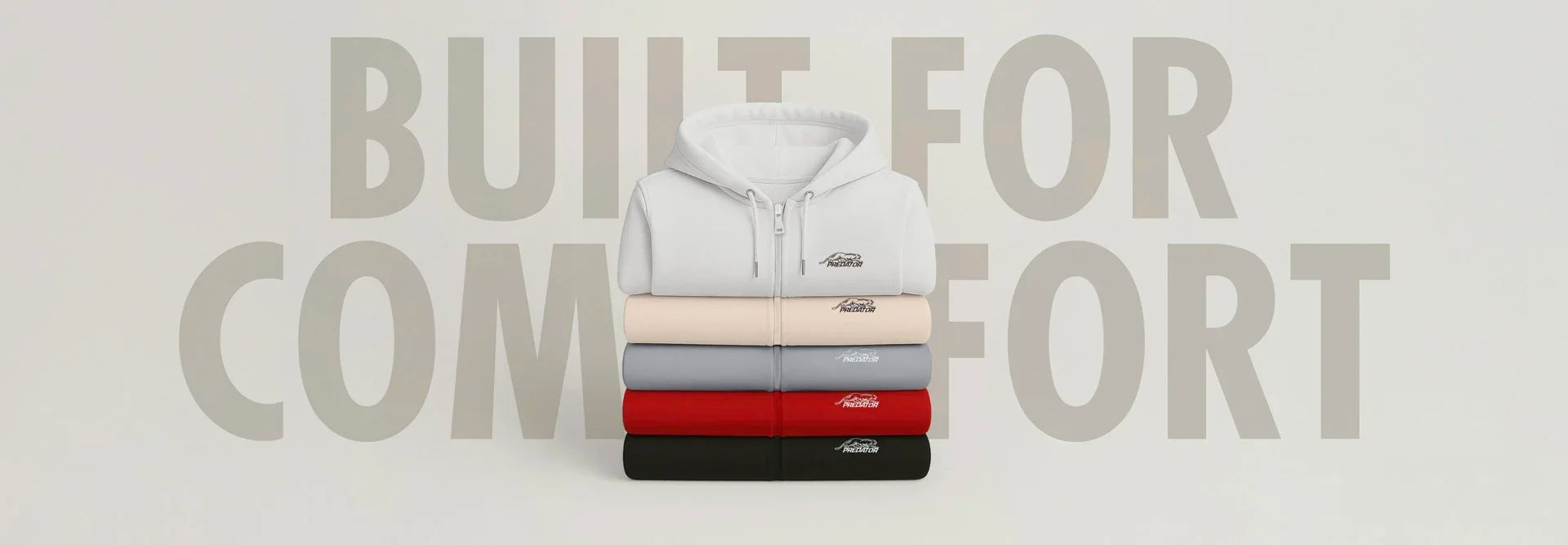 Wide image of a stack of folded hoodies, with text 'Built for Comfort' in the background