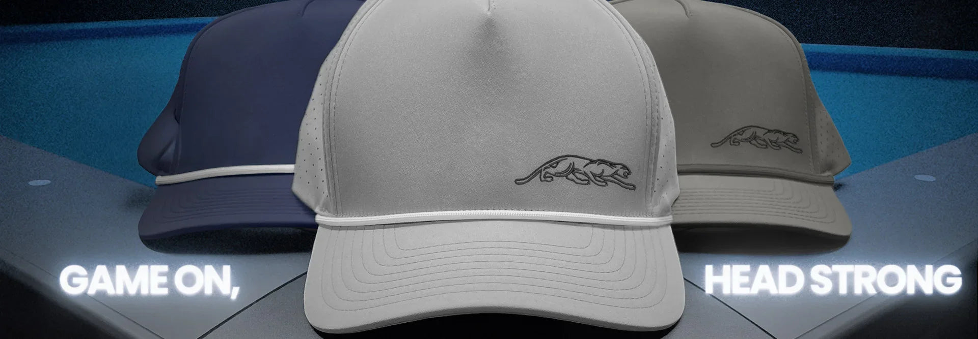 Close up of three caps with a cat outline logo embroidered and featuring text 'Game On' and 'Head Strong'.