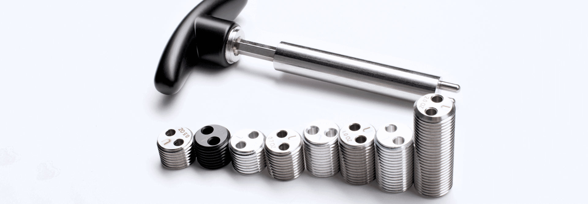 Metal tool with black handle and stack of metal weights