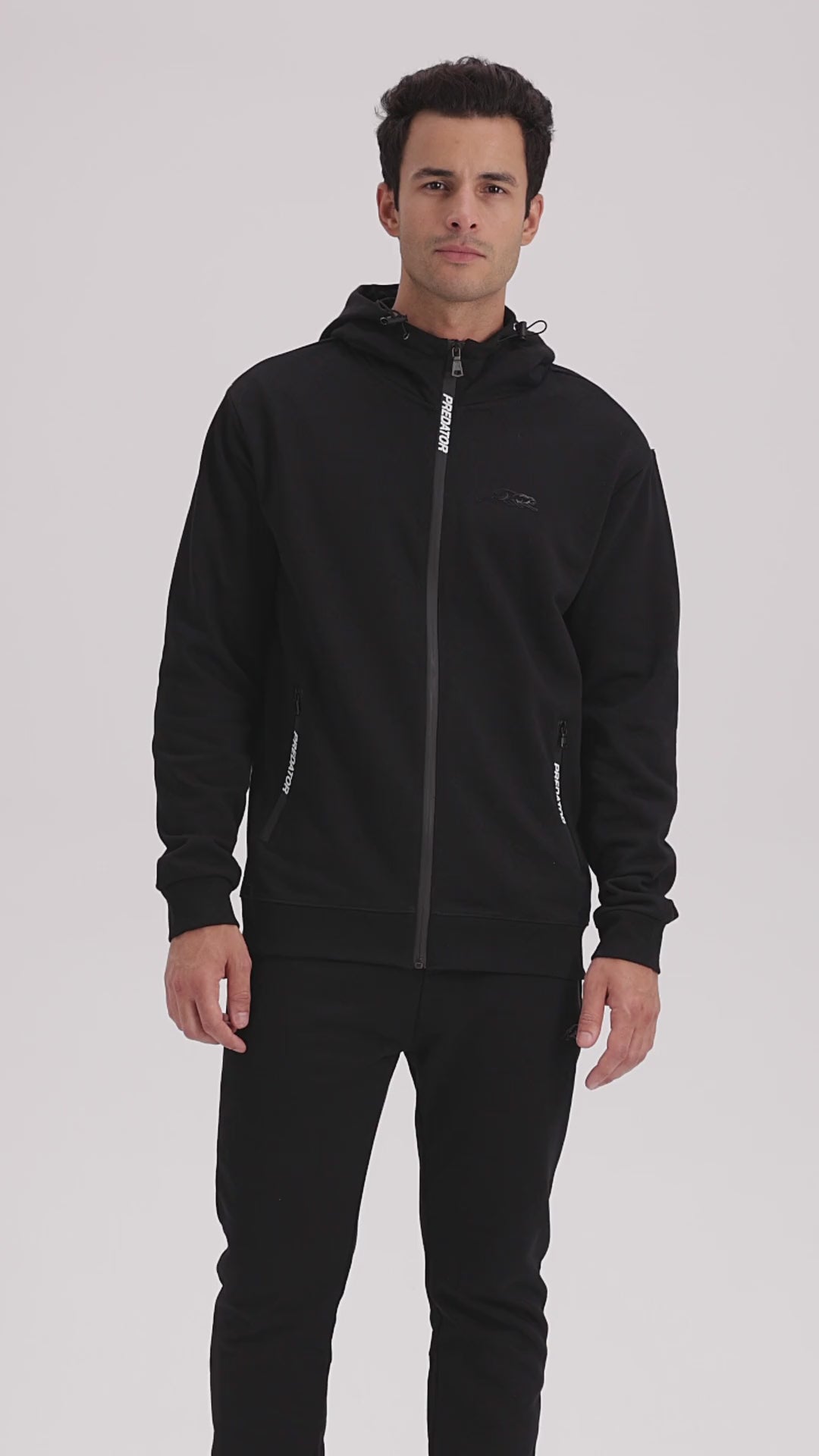 Man wearing black zip-up jacket with white PREDATOR branding