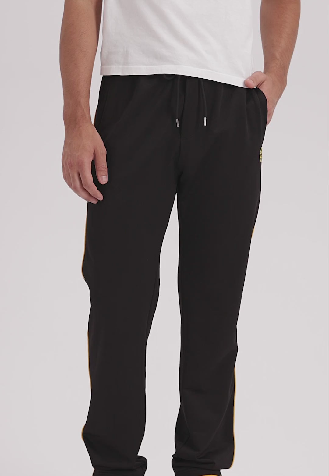 Man wearing black jogging pants with yellow accents
